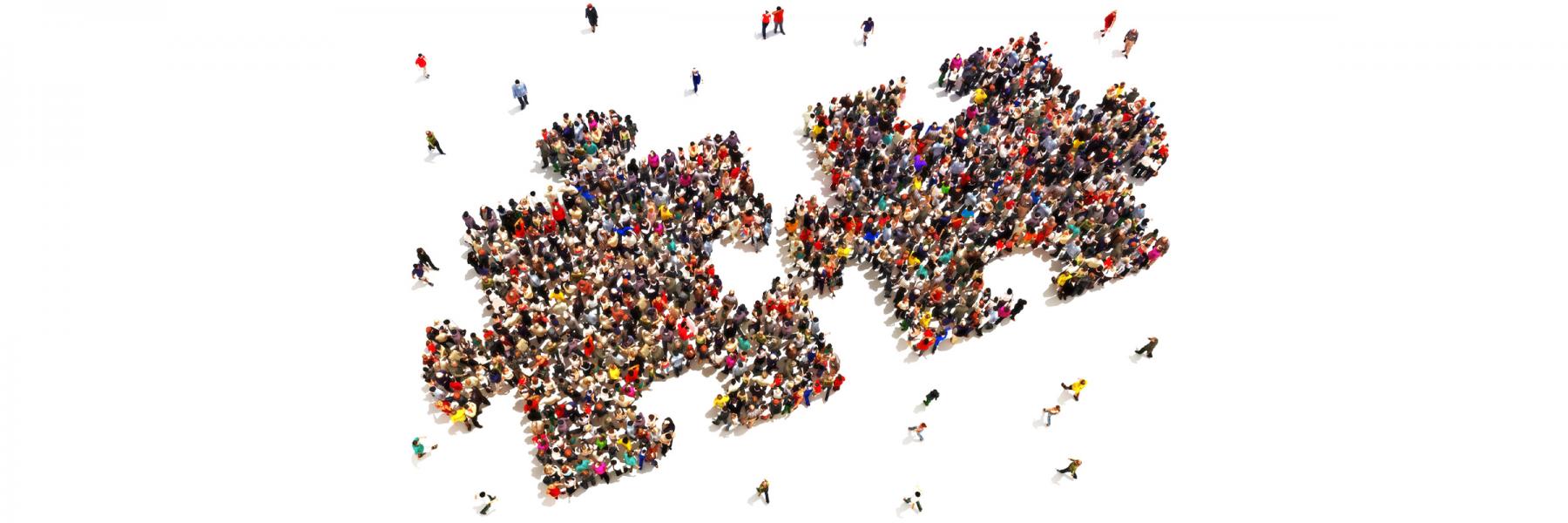 two interlocking jigsaw puzzle pieces comprised of two crowds of people