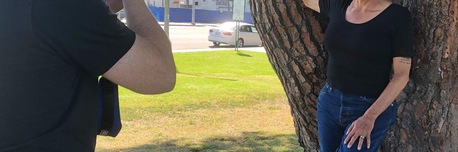 Transgender actor Alexandra Billings leaning against a tree while posing for a photographer