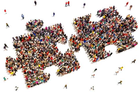 two interlocking jigsaw puzzle pieces comprised of two crowds of people