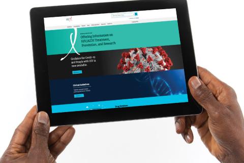 The web page of the DHHS HIV treatment guidelines appears on a tablet device being held by  hands